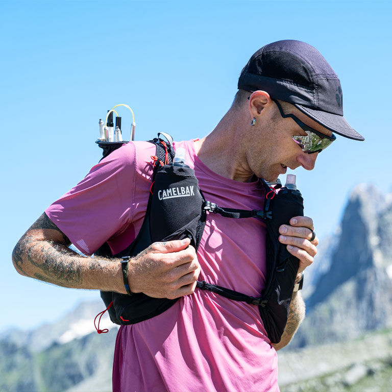 Man drinking water with his Apex run vest