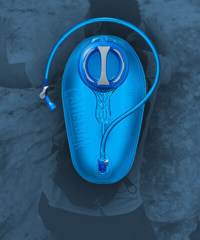 Blue reservoir with a person hiking in the background